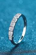 Moissanite Rhodium-Plated Half-Eternity Ring with sparkling stones on a blue background.