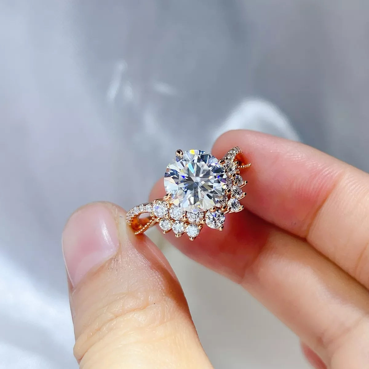 3 carat moissanite ring in sterling silver held between fingers, showcasing brilliance and elegance.