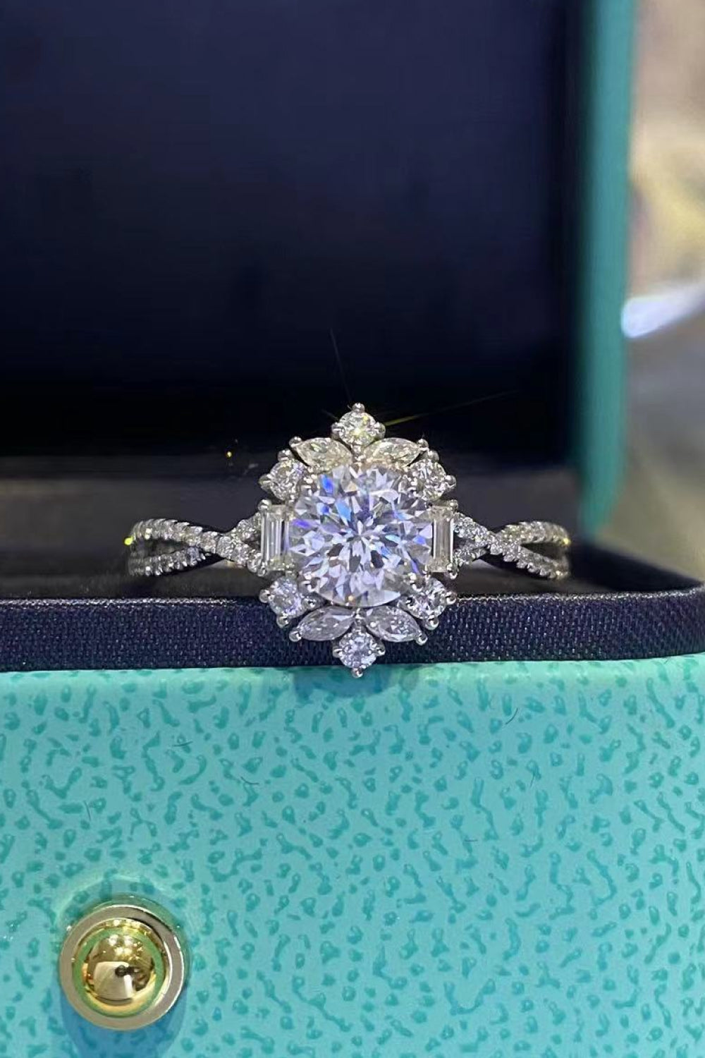 Floral 2 Carat Moissanite Crisscross Engagement Ring displayed in a box with a sparkling design.